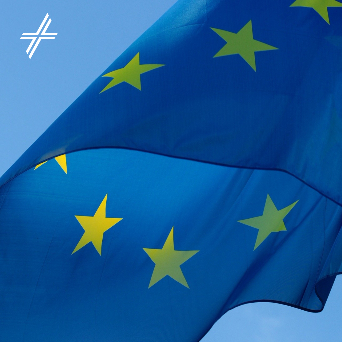 Europaflagge vor blauem Himmel, links oben ist das weiße ZdK-Kreuz-Logo
